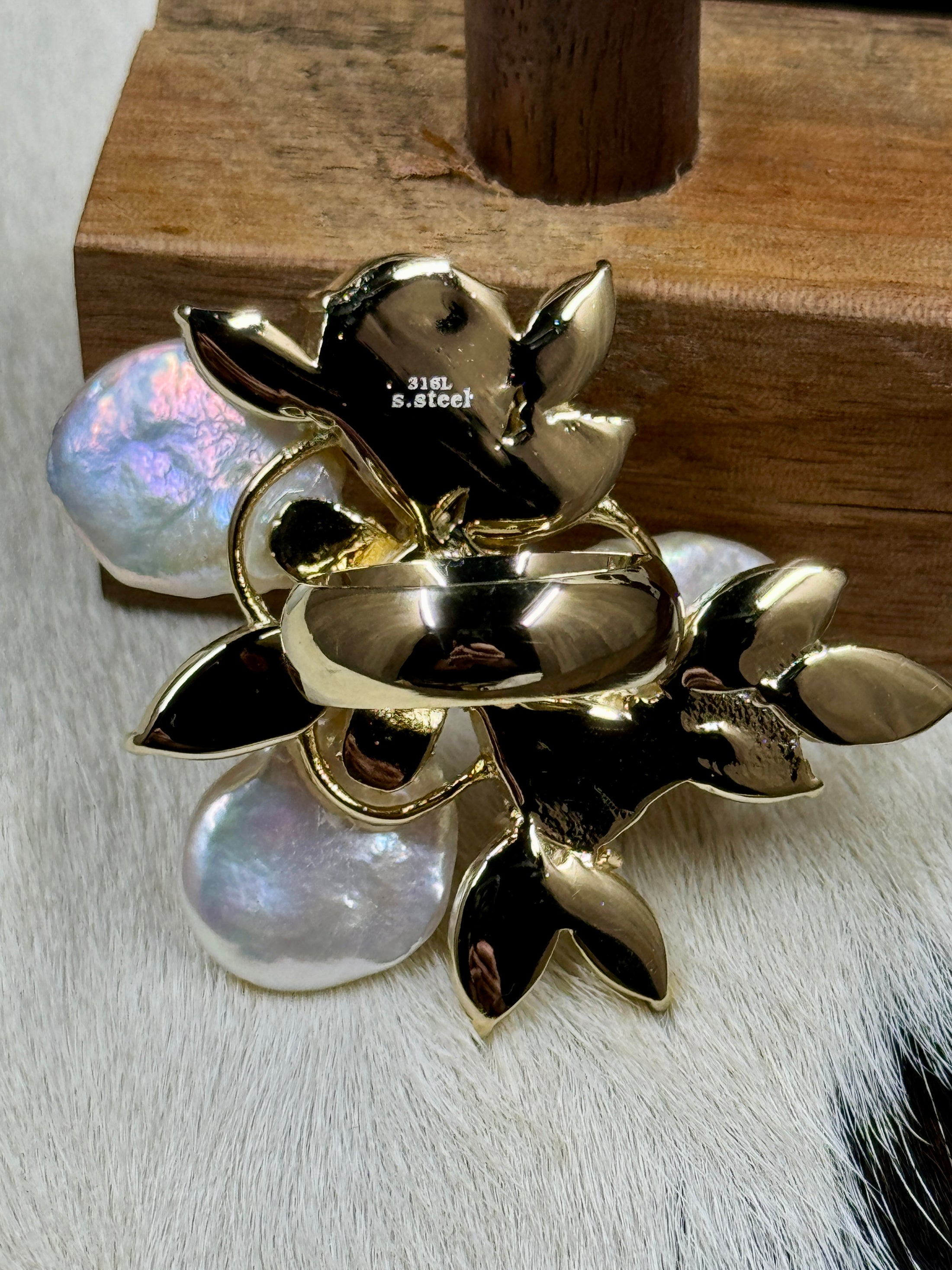 Back of Faux Pearl and Crystal Flower Ring on wood block with cowhide background