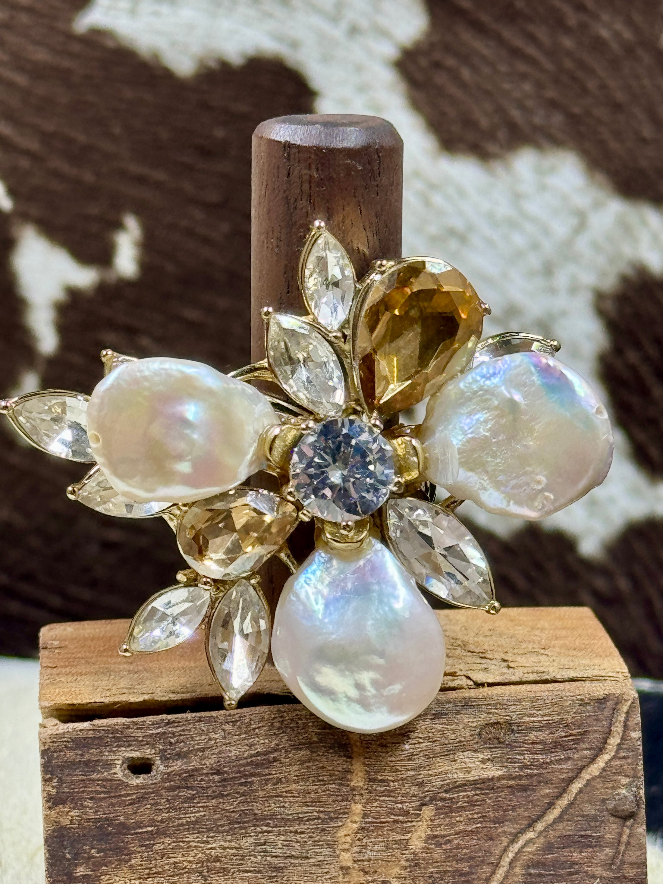 Faux Pearl and Crystal Flower Ring on wood block with cowhide background