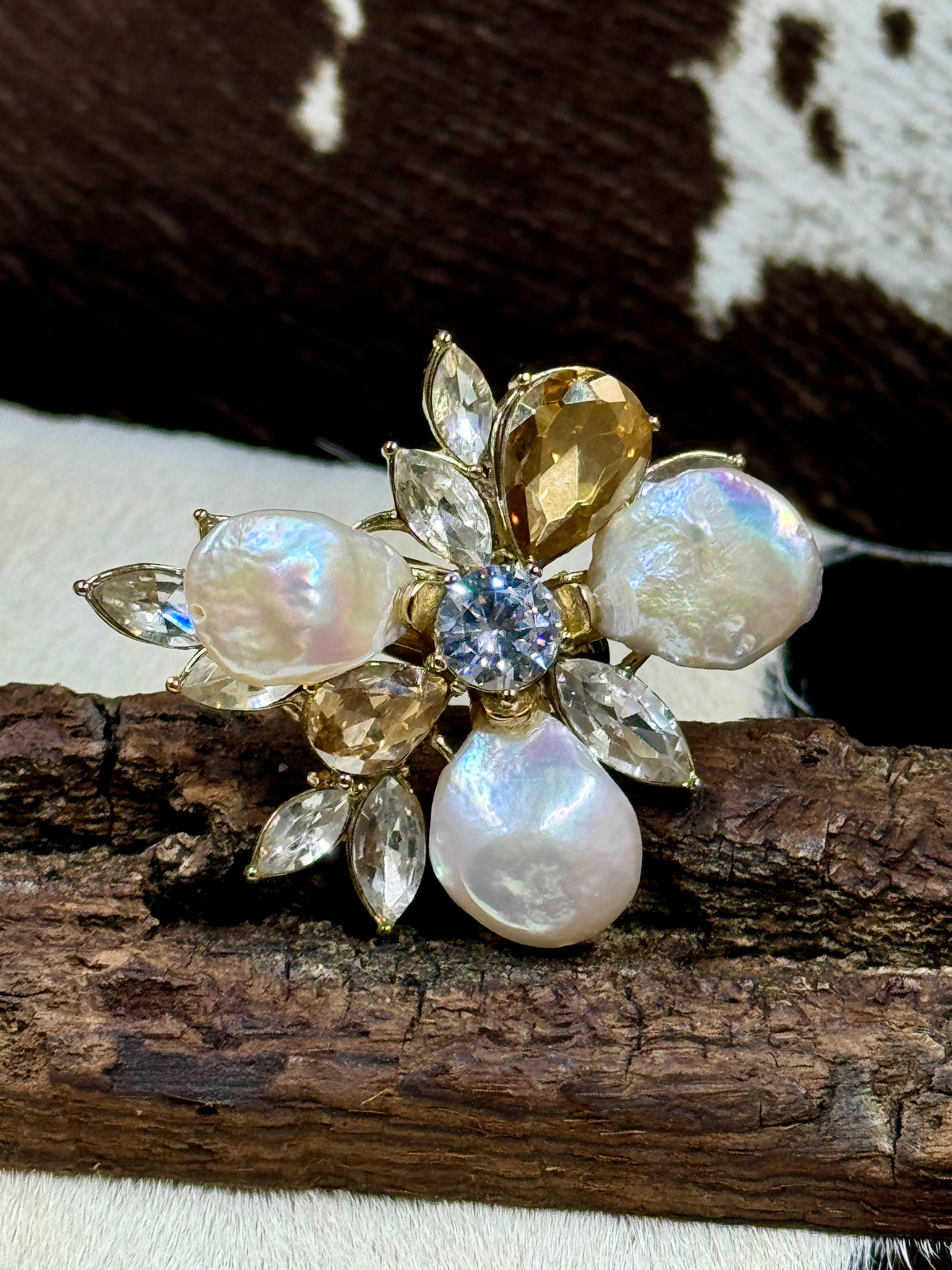 Faux Pearl and Crystal Flower Ring on wood block with cowhide background