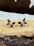 Load image into Gallery viewer, Garnet Butterfly and Sterling Earrings on wood block with cowhide background
