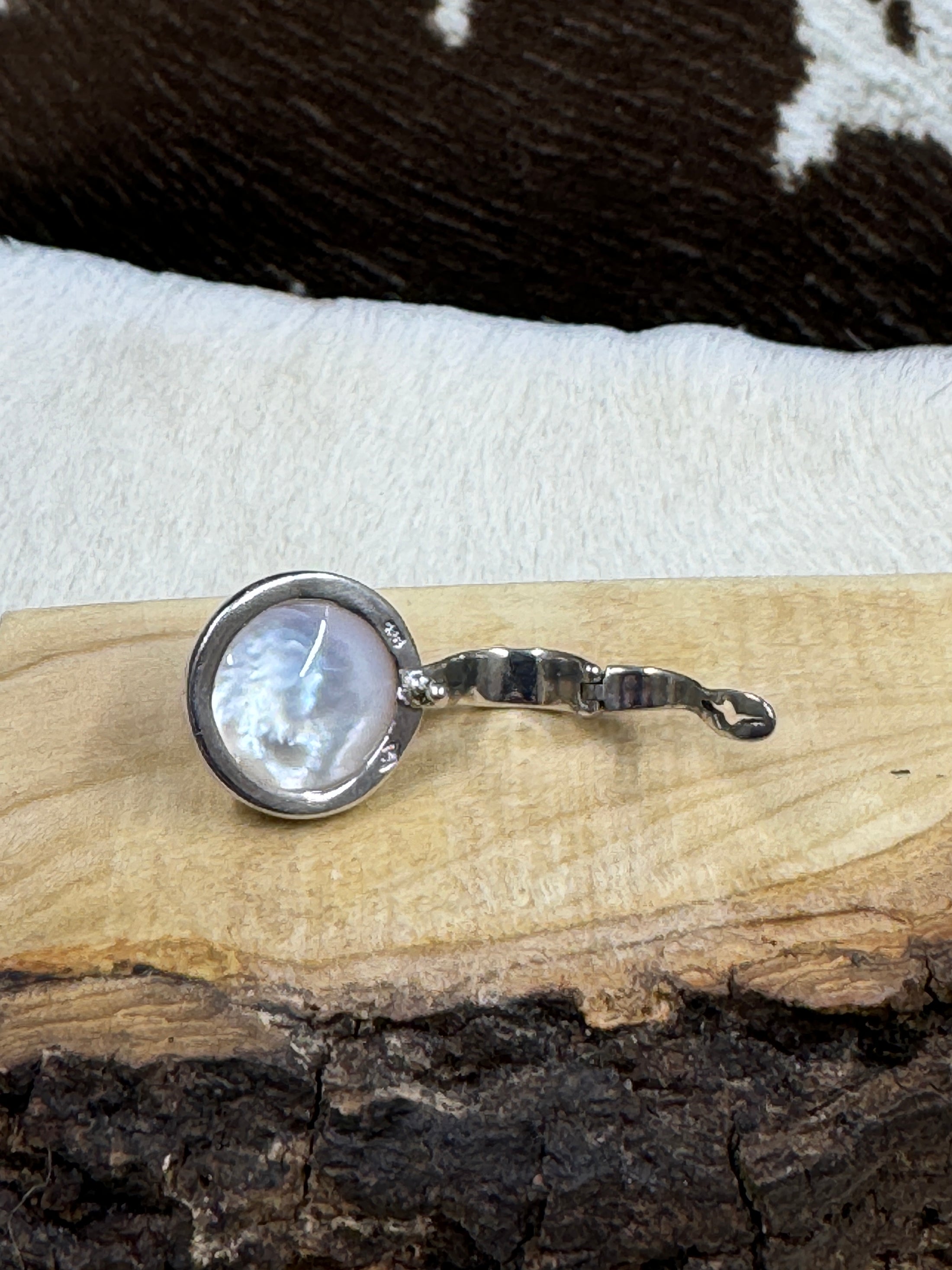 back side of Faux Pearl and Sterling Silver Necklace Enhancer on wood board with cowhide background