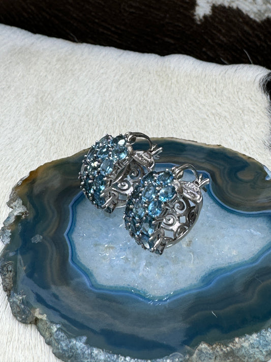 Blue Topaz and Sterling SIlver Earrings on blue rock with cowhide background