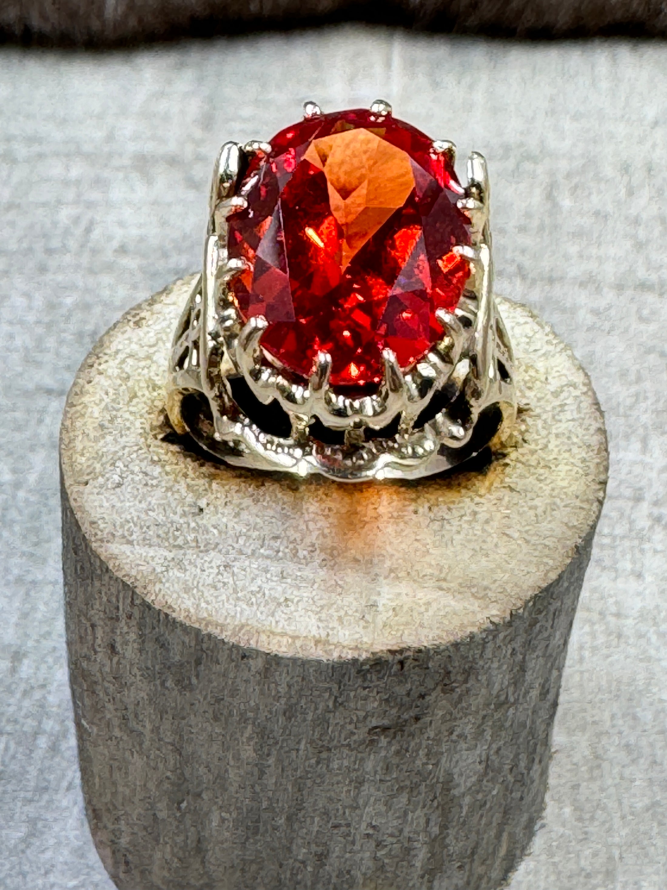 Egyptian Revival Vintage 10K Gold and Orange Sapphire Ring on wood piece with wood background