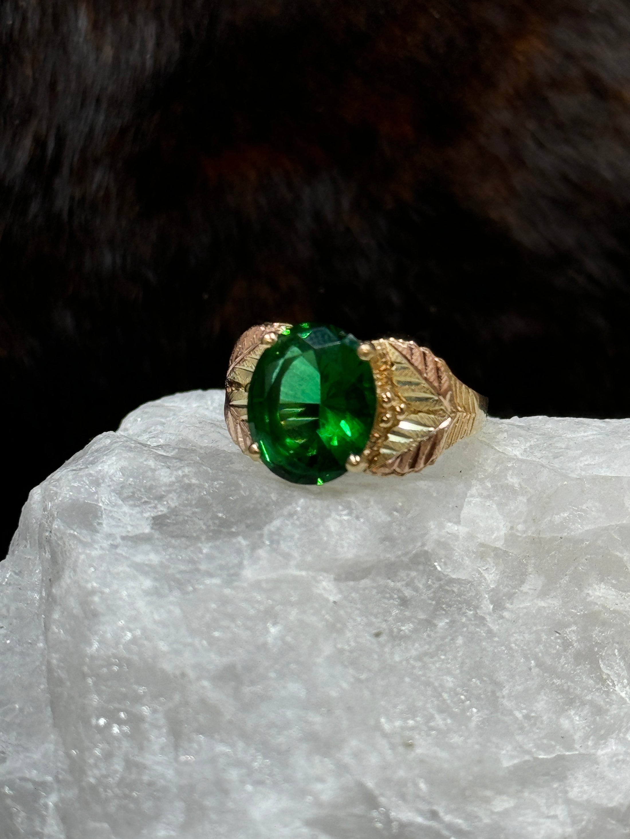 Black Hills Gold Coleman 10K Lab Created Emerald  on white rock with fur background