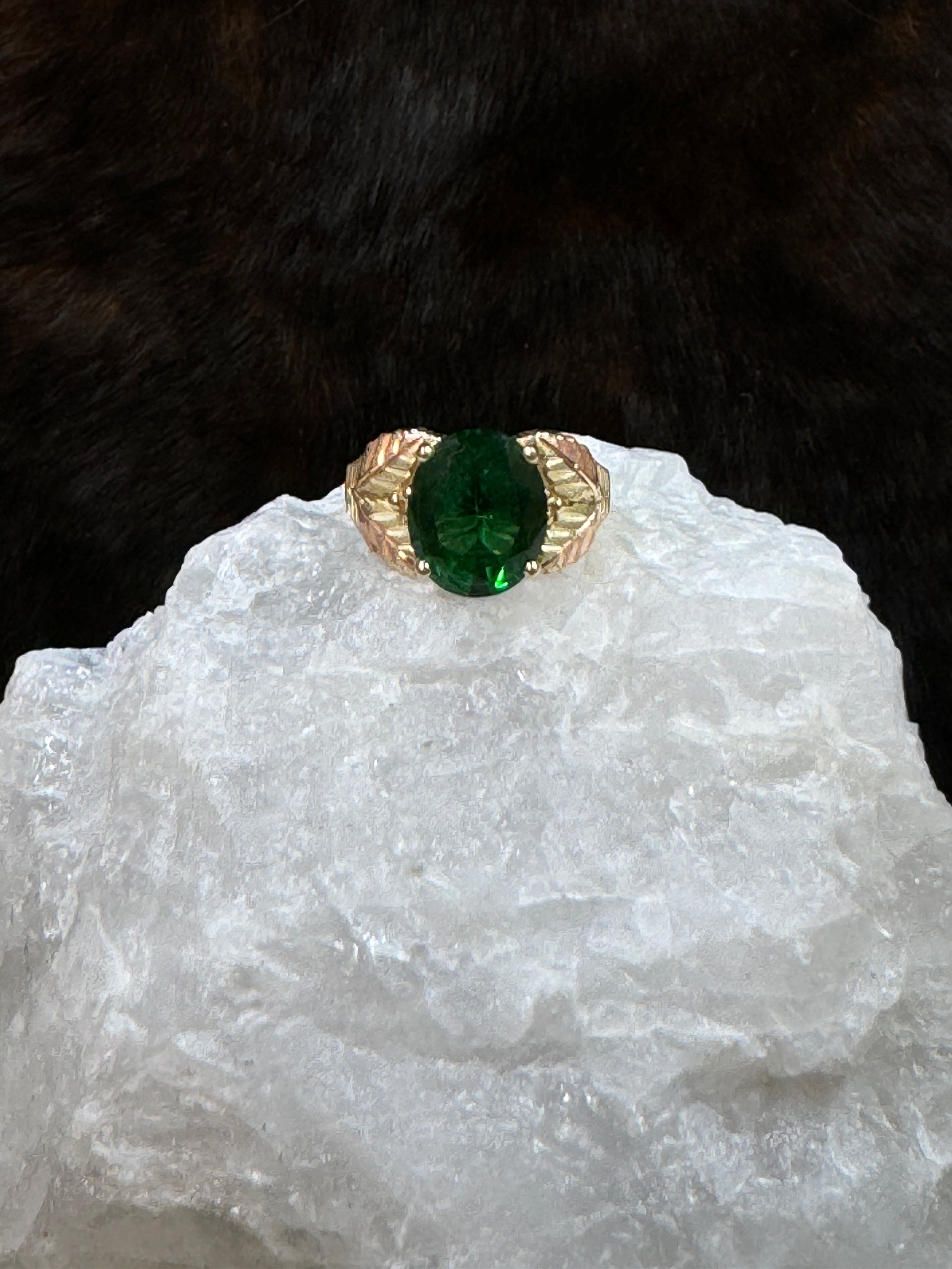 Black Hills Gold Coleman 10K Lab Created Emerald  on white rock with fur background