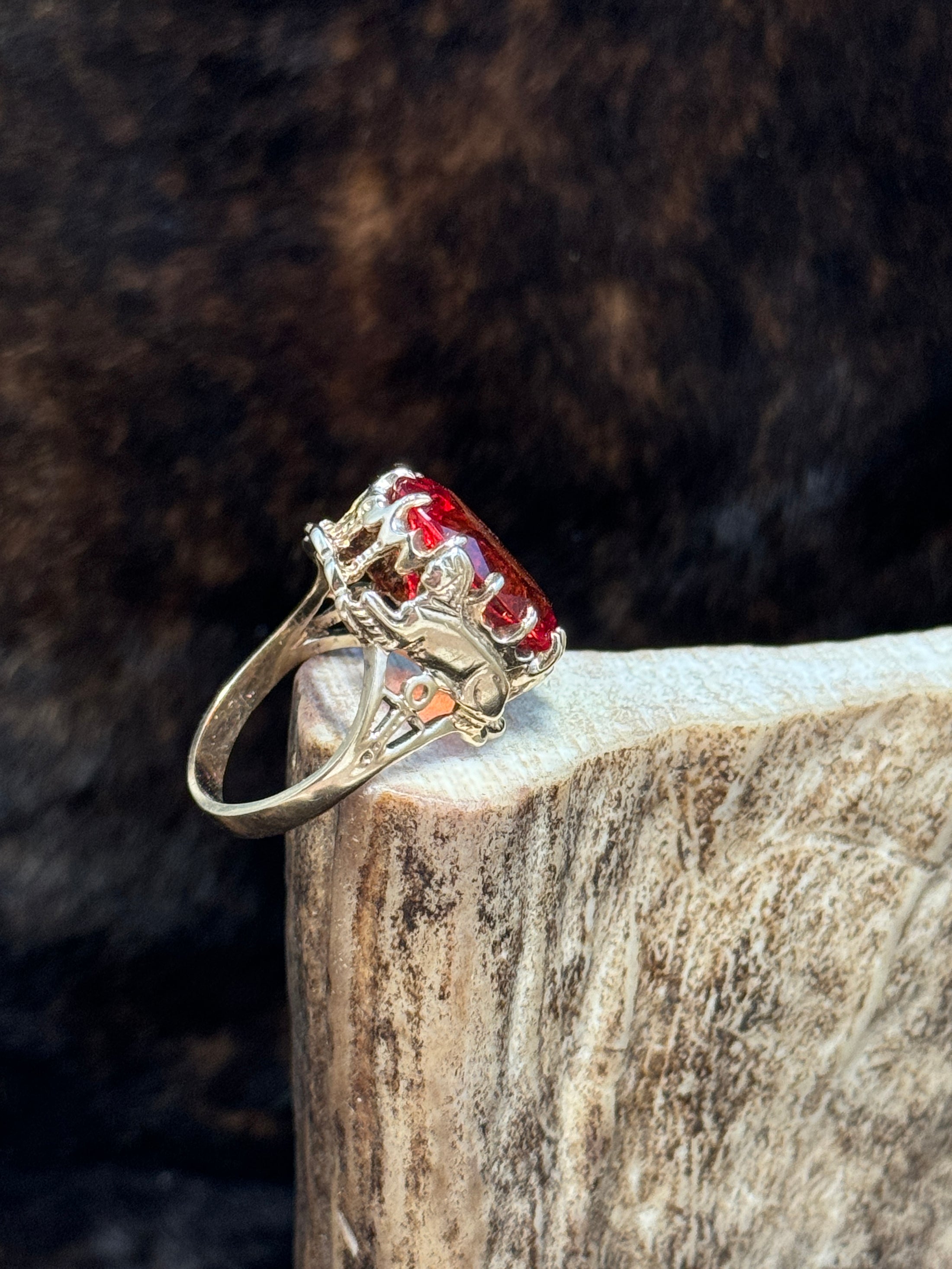 Side view of Egyptian Revival Vintage 10K Gold and Orange Sapphire Ring on moose antler with fur background