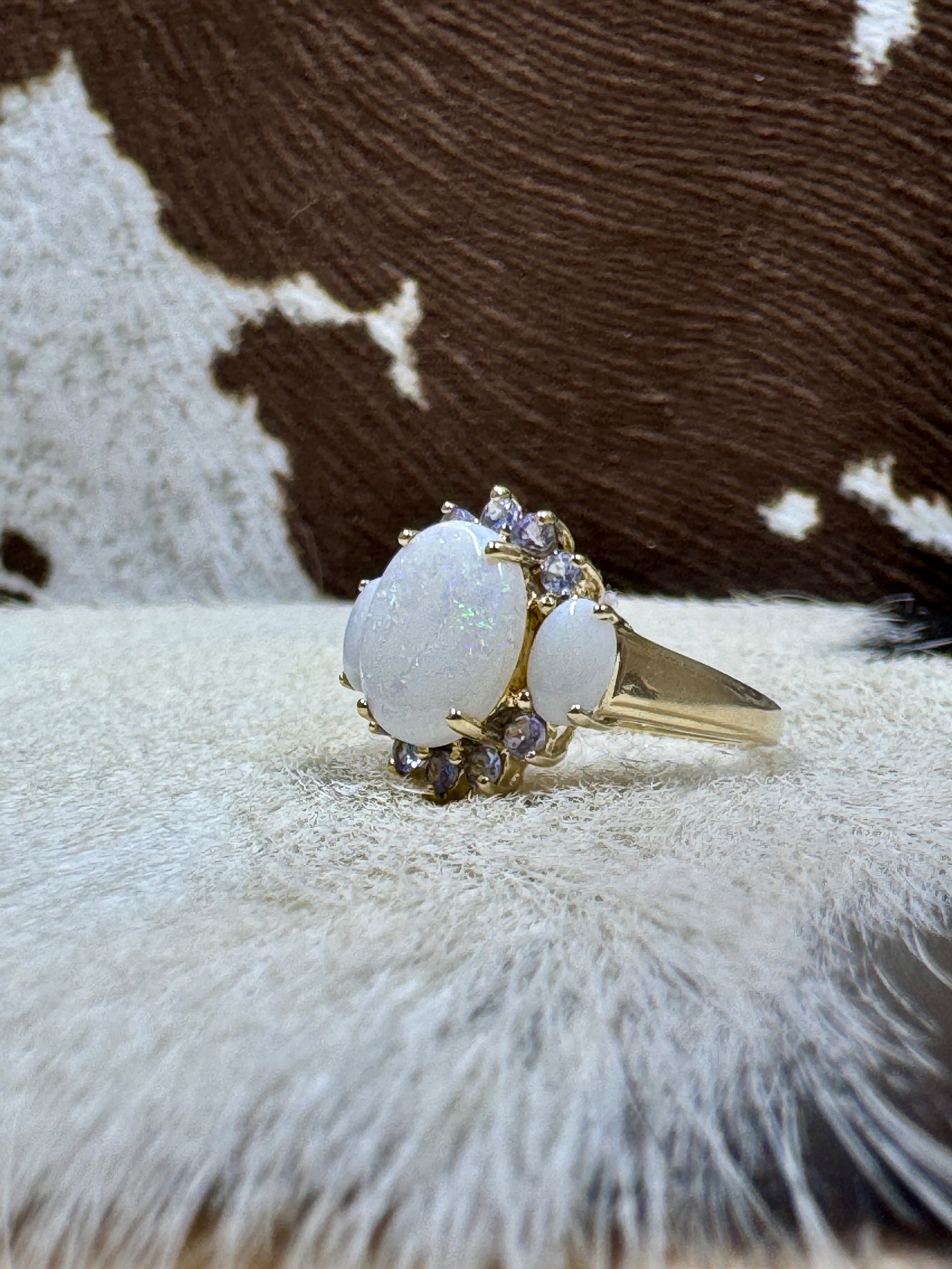 Tanzanite and Opal 10K Gold Ring on cowhide with cowhide background