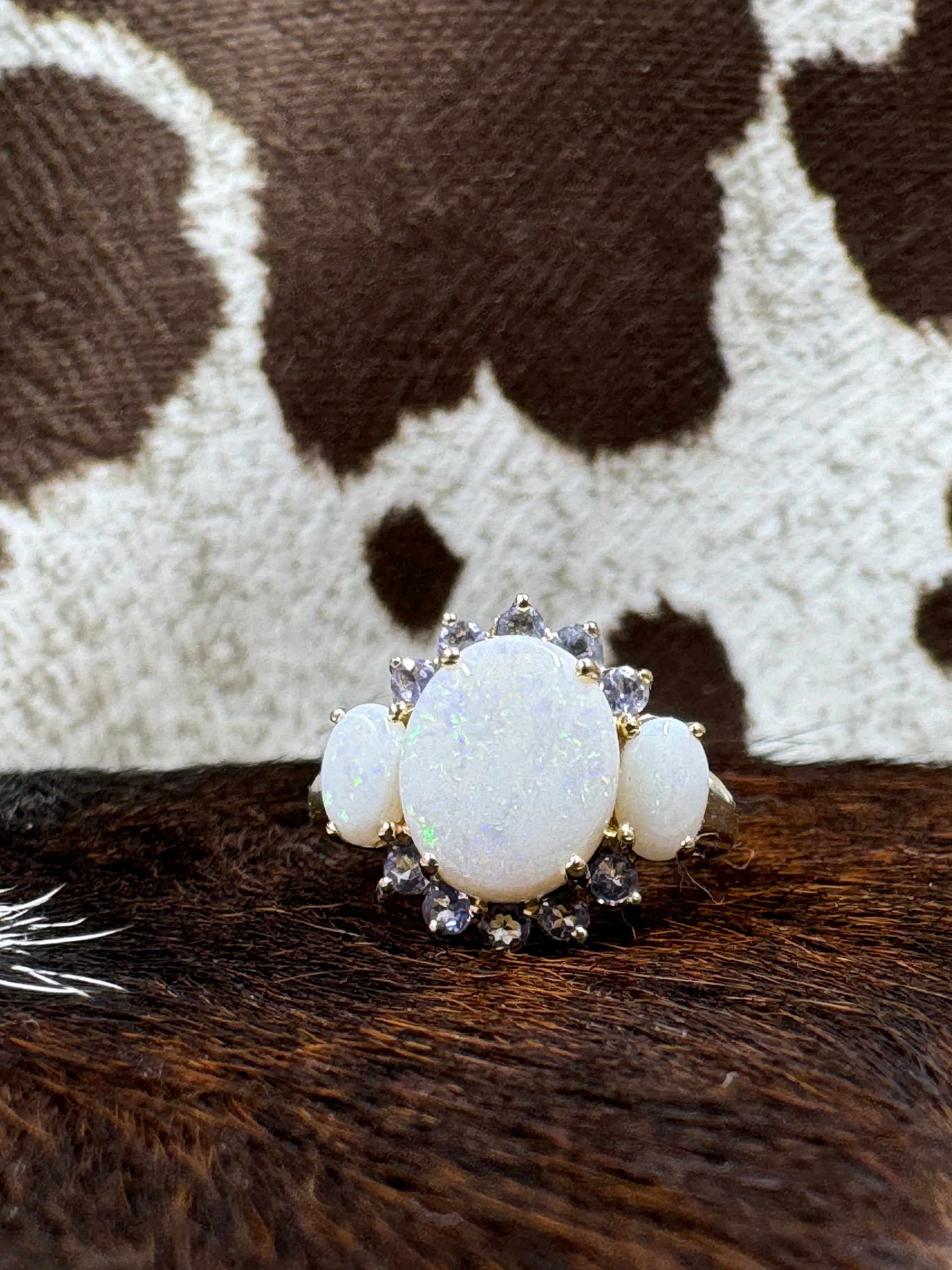 Tanzanite and Opal 10K Gold Ring on cowhide with cowhide background