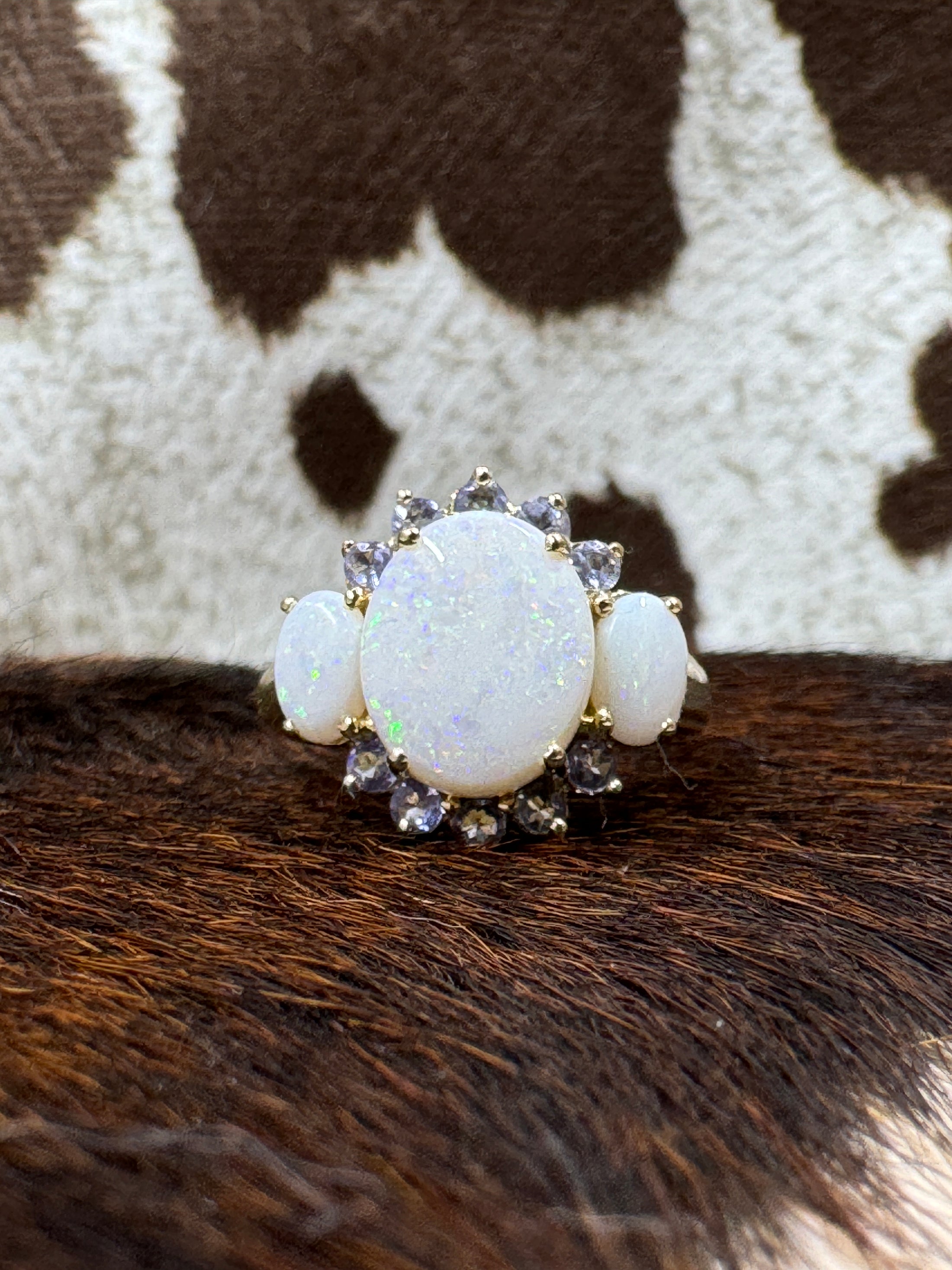 Tanzanite and Opal 10K Gold Ring on cowhide with cowhide background