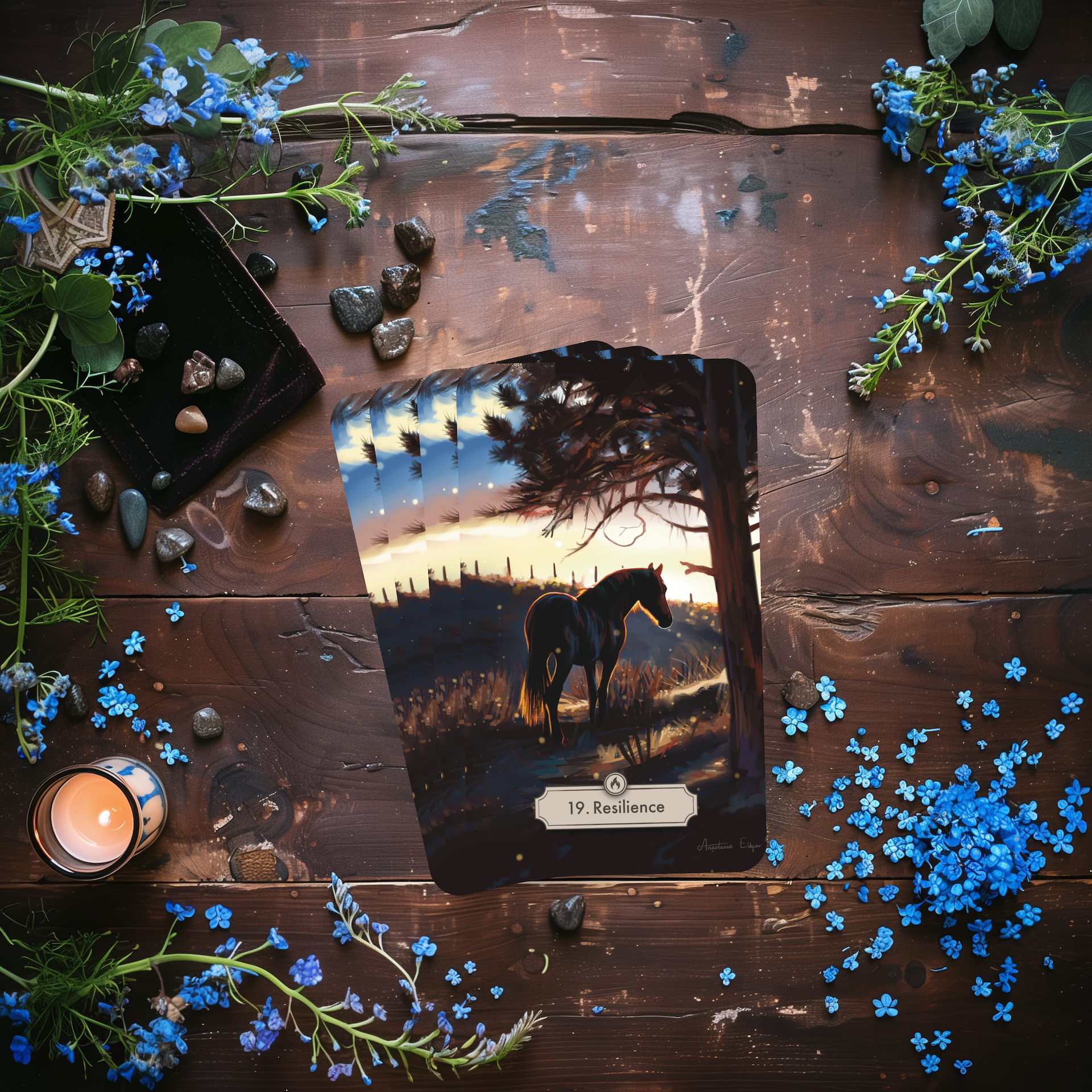 Resilence card laying on a desk with forget me nots and stones.